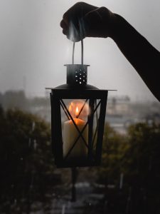 Vertical selective shot of a person holding black candle lantern